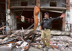 A policeman keeps people away from the site of a bomb blast in a hotel in Peshawar