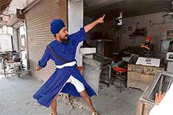 An Akali activist forcing closure of a shop in Amritsar on Wednesday.