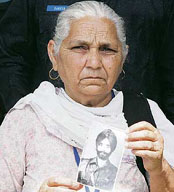 Nirmala Kaur holds a picture of her missing husband, Assa Singh.