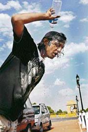 A man pours water on head to get rid of the scorching temperature in the National Capital