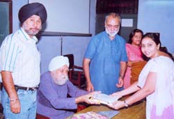 Playwright Gursharan Singh awards a certificate to a participant at Academic Staff College in Amritsar.