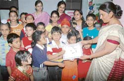 Headmistress of Ryan International school Pooja Sharma distributes certificates to children on the concluding day of a 15-day summer workshop held at the school in Patiala