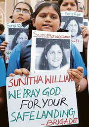 School children hold placards for the safe return of Sunita Williams from space at St. Joseph's Cathedral in Hyderabad.