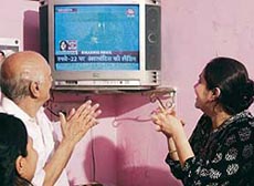 Vitthalbhai Patel, 79, uncle of Sunita Williams, claps as he watches, with family members, the televised landing of Atlantis at their home in Ahmedabad on Saturday.
