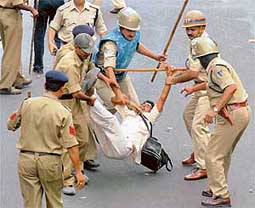 Policemen take away one of the teachers demonstrating under the banner of Madhya Pradesh Shiksha Guarantee Guruji Sangh for regularisation of their services near the Chief Minister's residence in Bhopal of Tuesday. 