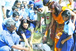 Sonali Gaur, president, Air Force Wives Welfare Association, helps schoolchildren of Air Force School plant saplings on the school campus