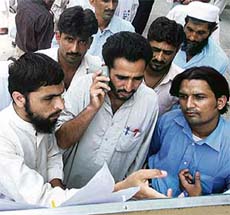 Relatives check lists of missing Pakistani religious students of the Red Mosque in Islamabad