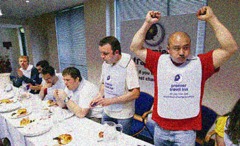 Lup Fan Yau celebrates after winning the All You Can Eat Breakfast Championships in Central London. Competitors had 12 minutes to eat as many plates of breakfast. Each plate comprised a fried egg, a bacon rasher, a sausage, a croissant and three mushrooms.