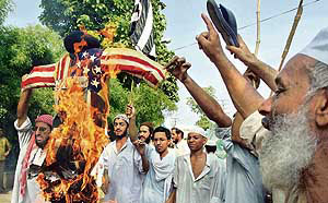 Pakistani activists of the hardline six Islamic party alliance, the Muttahida Majlis-e-Amal (MMA), torch an effigy of President Pervez Musharraf with a US flag during an anti-Musharraf protest rally in Lahore on Friday against the military operation against Islamic students in Lal Masjid.