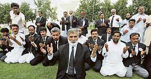 Pakistani lawyers offer prayers after the reinstate- ment of CJ Chaudhry in Islamabad.