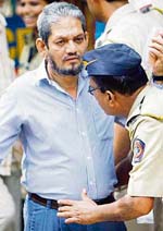 Yusuf Nulwala, accused in the 1993 Mumbai bombings, is frisked as he arrives at the special TADA court in Mumbai