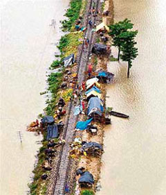People take shelter on a railway track of the Darbhanga-Sitamandhi railway line near the Kamtaul railway station after the area was flooded by the Bagmati river in North Bihar on Thursday.
