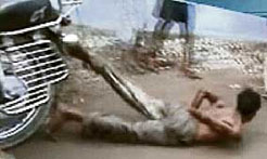 A TV grab shows a man being dragged after he was tied to a motorcycle in Bhagalpur on Tuesday.