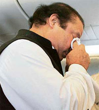 Nawaz Sharif wipes his eyes before disembarking a Pakistani aircraft in Islamabad on Monday.
