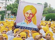 Students hold a portrait of Bhagat Singh outside the Jallianwala Bagh