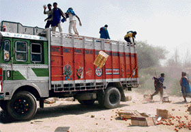 Porters attack a truck carrying tomatoes near the Attari checkpost on Monday.