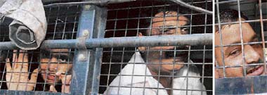 Former MPs Anand Mohan and Lovely Anand wave to their supporters from inside a police van at Civil Court in Patna after the final judgment in the murder case of Gopal Ganj district magistrate G. Krishnaiya