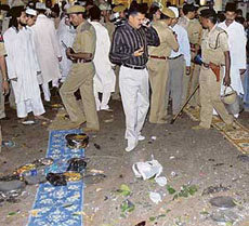 Security personnel and bystanders gather around scattered debris at the entrance to The Khwaja Moinuddin Chishti Dargah (shrine) in Ajmer, on Thursday, after the blast.