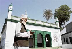 A man prays outside the shrine of Sufi saint Hazrat Noor Mohammad Chisti in Neval village in Karnal.