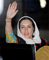 Former Pakistani prime minister Benazir Bhutto waves to her supporters upon her arrival outside Islamabad International Airport in Islamabad, on Tuesday.