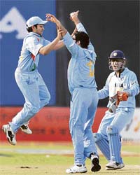 Rohit Sharma (left) and captain Mahendra Singh Dhoni (right) congratulate Yuvraj Singh for the wicket of Shoaib Malik during the third one-day international between India and Pakistan at the Green Park Stadium in Kanpur