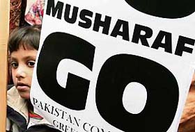 A Pakistani boy living in Greece holds a placard, reading Go Musharraf, during a demonstration in Athens