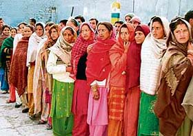 Women await their turn for voting at a polling station in the Bharmour constituency