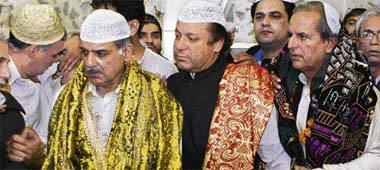 Ex-Pakistan PM Nawaz Sharif, centre, and his brother Shahbaz Sharif, left, visit the shrine of famous saint Data Darbar in Lahore