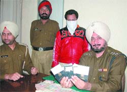 Police officials show passports and money seized from a travel agent in Jalandhar on Thursday.