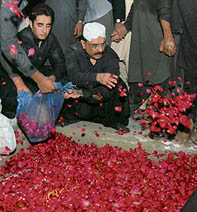 sif Ali Zardari, husband of former Pakistan Prime Minister Benazir Bhutto, and his son Bilawal shower rose petals on the grave of Benazir