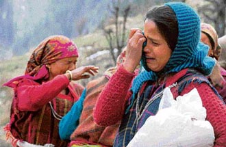 Women mourn the loss after the devastating fire in Malana on Saturday.