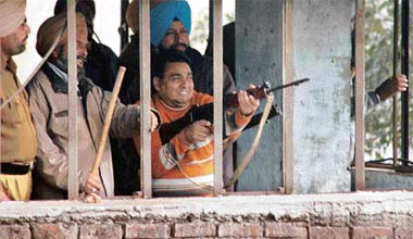 Armed security personnel aim at agitating prisoners in an effort to control the situation in the Jalandhar Central Jail