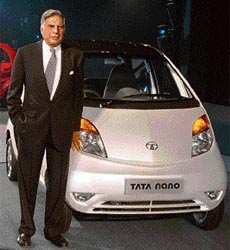 Ratan Tata poses in front of the Tata Nano car during the launch in New Delhi, Thursday.