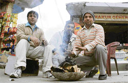 TAKE A BREAK: Shopkeepers warm themselves as the chilled winds continued to blow in Shimla