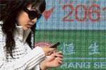 A Chinese investor views a stock price board showing the green colouring which indicates falling prices.