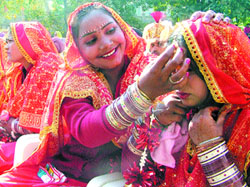 A bride adjusts jewellery of another bride during a mass marriage function organised by the Rotary Club, Amritsar Midtown, in the city.