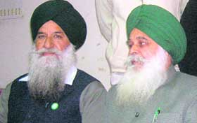 BKU president Ajmer Singh Lakhowal (right) addresses mediapersons in Ludhiana on Friday.