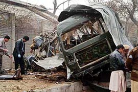 Pakistani investigators examine a destroyed army vehicle at the site of a suicide attack in Rawalpindi on Monday.