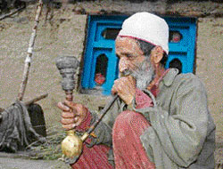 An old man relaxes with a traditional hukka during the Jukaro festival in the Pangi valley