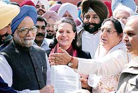Prime Minister Manmohan Singh and Congress president Sonia Gandhi being greeted by a delegation of Punjab farmers in New Delhi
