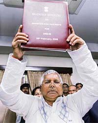 Railway minister Lalu Prasad Yadav holds a copy of the Railway Budget as he poses for media representatives at his office in New Delhi