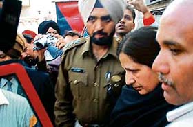 Davinder Singh Garcha’s wife being taken from her residence for a search of her bank lockers in Jalandhar