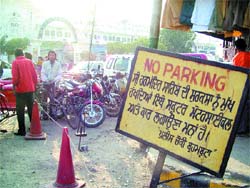 Two-wheelers and cars continue to be parked at the Brahmbuta market despite the “No parking” board put up by the local police in Amritsar.