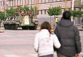 Chinese soldiers sit on an armoured personnel carrier as they guard the streets in Lhasa