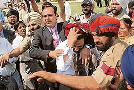Police personnel try to save an NRI groom from agitating relatives of his first wife at Kapurthala on Wednesday.