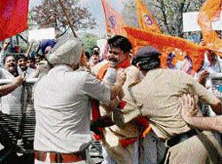 Chandigarh police personnel try to stop RSS activists after they broke the barricade during their protest against the killing of RSS activists in Kannur, Kerala, in Sector 22, Chandigarh on Friday.