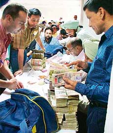 Participants deposit cash at the auction of sand quarries in Ludhiana