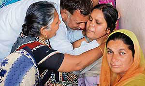 Anju, daughter of Mam Chand, who is sitting on a dharna to protest the deaths in her family, being consoled by her relatives in Pehowa on Tuesday.