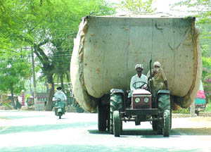 Overloaded trucks and tractor-trailers carrying wheat chaff pose a great traffic hazard on busy roads.