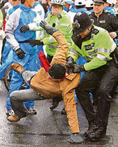 The British police arrests a man who attempted to grab the Olympic Torch in London on Sunday.